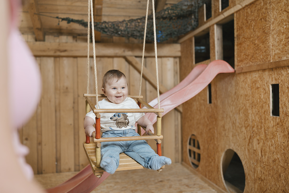 Kleinkind in einer Schaukel in unserem Indoor-Spielplatz