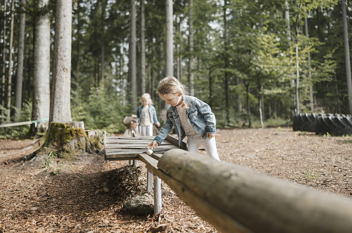 Zwei Kinder spielen mit der Kugelbahn