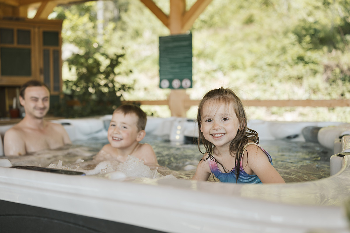 Ein Mann und zwei Kinder im Whirlpool