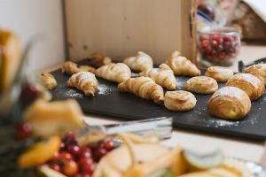 Frühstücksbuffet mit frischen Croissants, süßem Gebäck und Obst