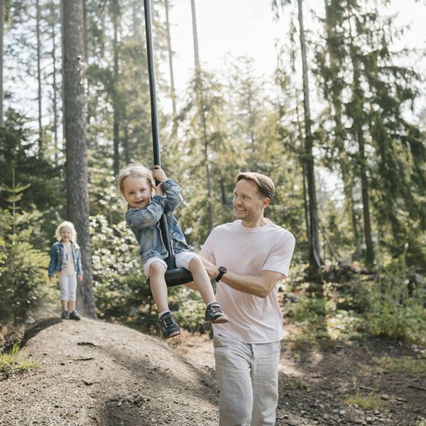 Glückliches Mädchen auf der Seilrutsche mit ihrem Vater